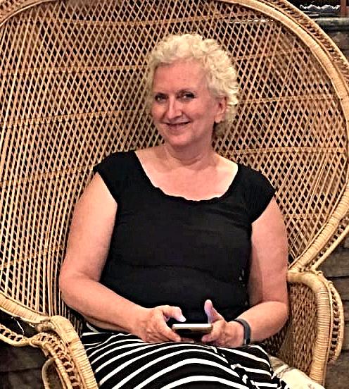 Sue Molenda sitting in a wicker chair