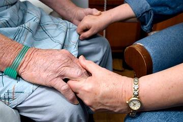 Hands holding the hands of a patient