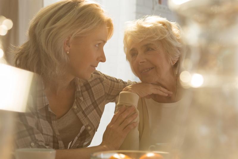 Middle aged female caregiver spending time with older lovely woman