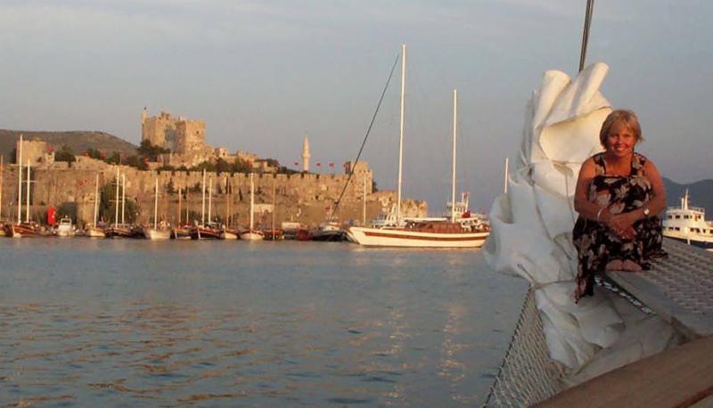 Carol on yacht at sunset with castle and harbor