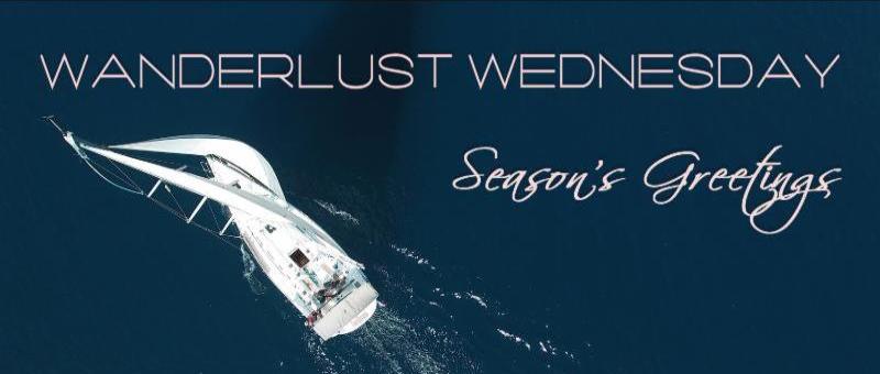 Aerial view of white sailboat banner for Wanderlust Wednesday Seasons Greetings