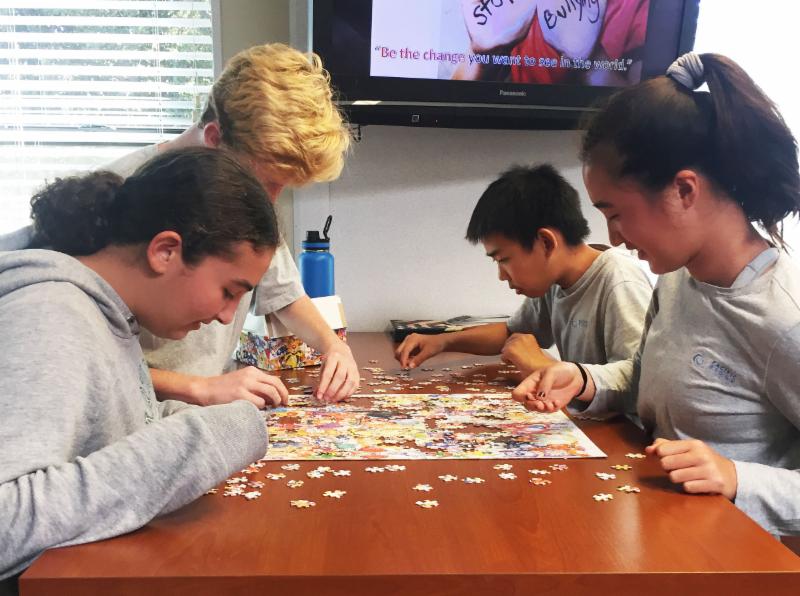 Students work on a puzzle in the library.