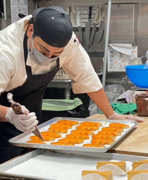 Piping icing on Halloween cookies