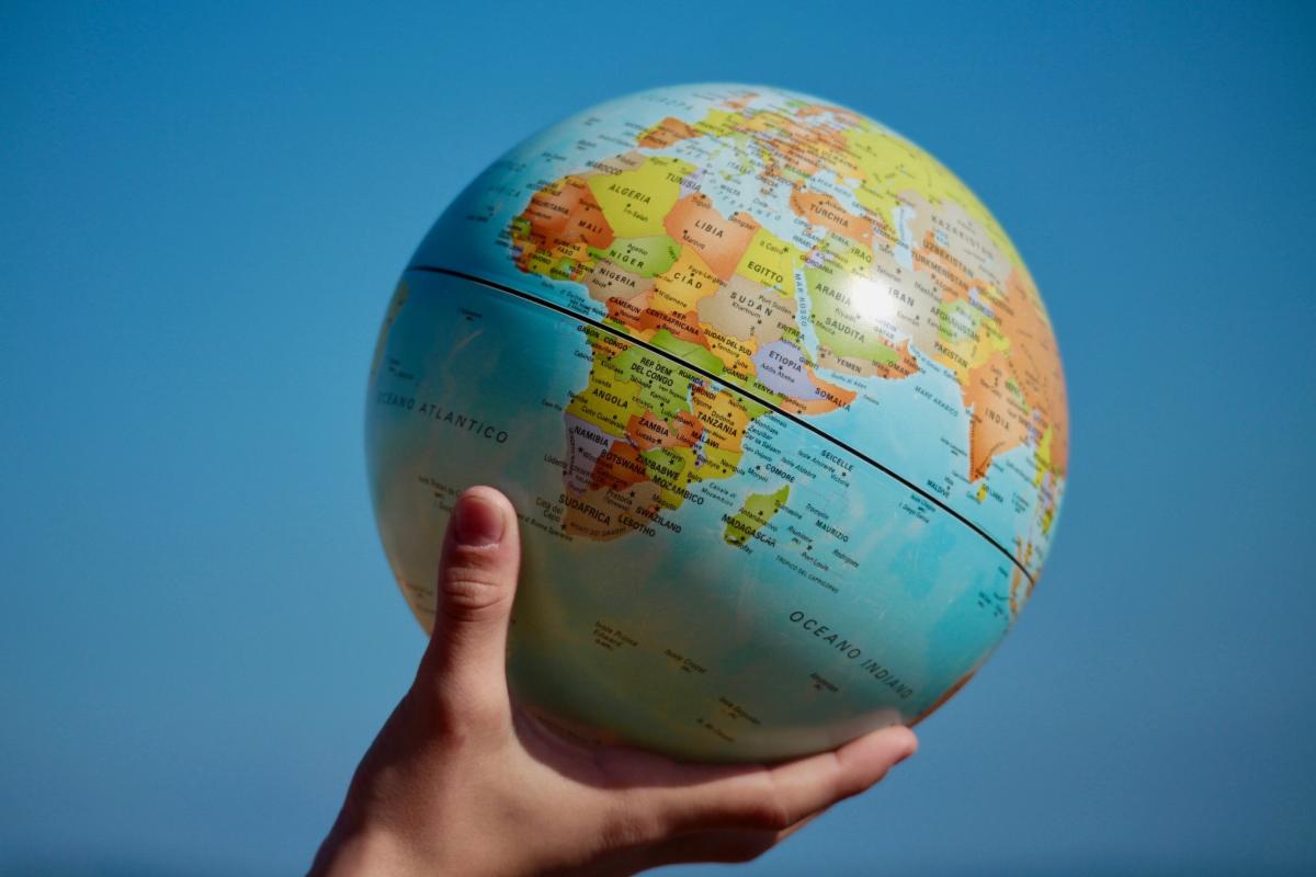 A hand holding the globe