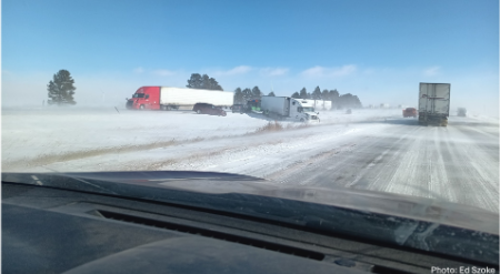 Una carretera nevada con camioneros; uno de ellos deslizándose fuera de la carretera.