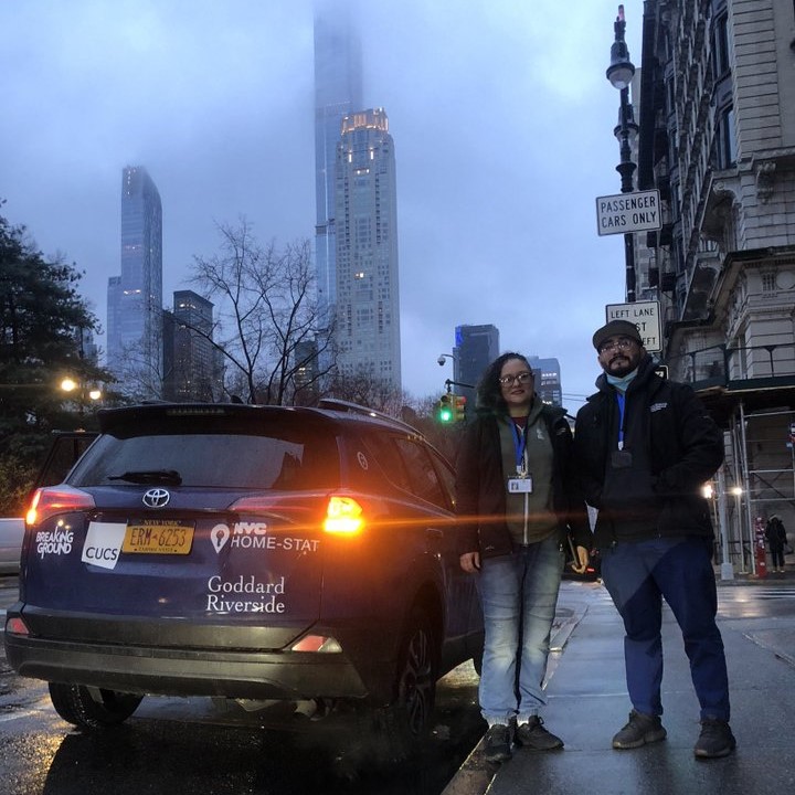 A man and woman stand next to a Manhattan Outreach Consortium vehicle in pre dawn light on the Upper West Side