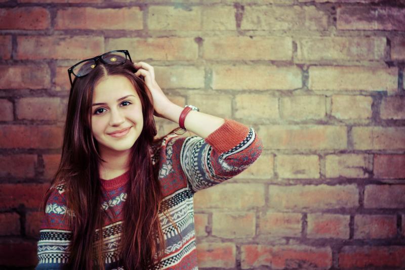 Hispanic teen girl against a brick wall