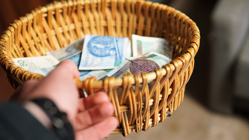 concept photo showing a donation tray in a church. Collecting tributes during the Holy Mass. Controversy over church finances