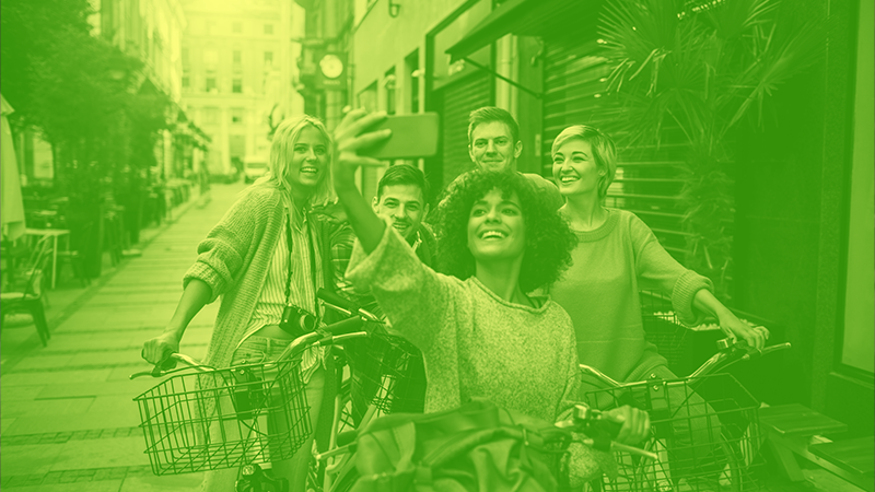 green photo of teens smiling for group selfie in urban outdoor setting with text about the hotline in white