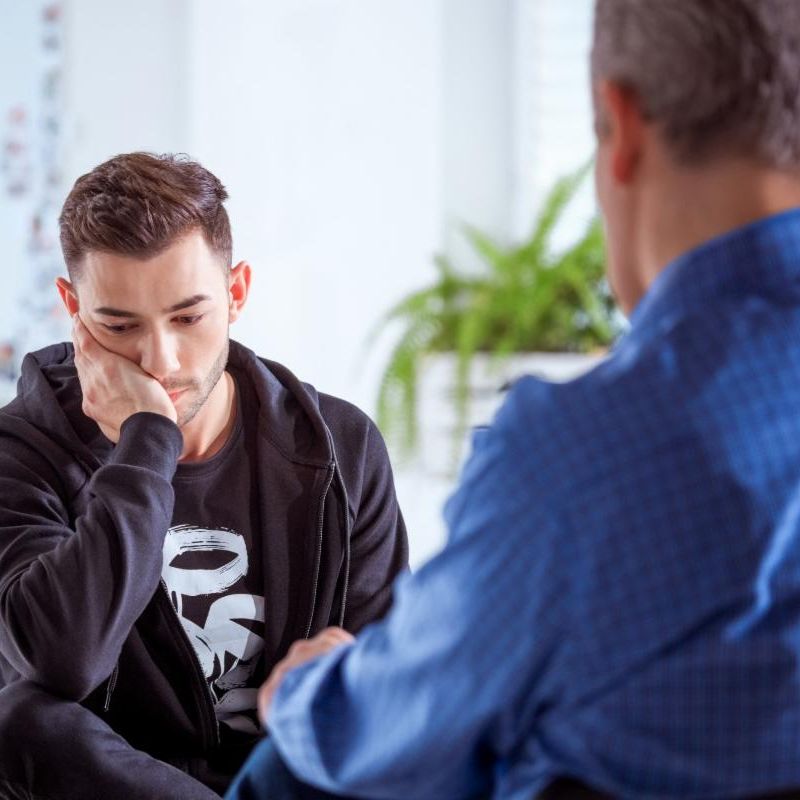 sad male youth with therapist