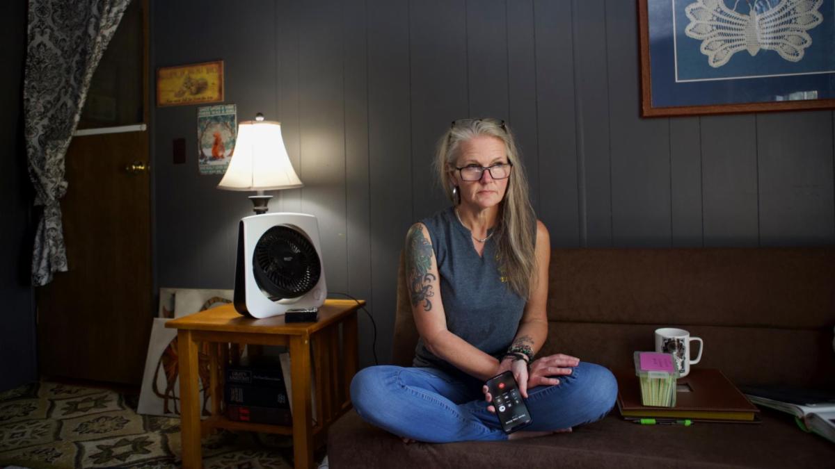 Never Use ALone hotline worker sitting on couch with cell phone