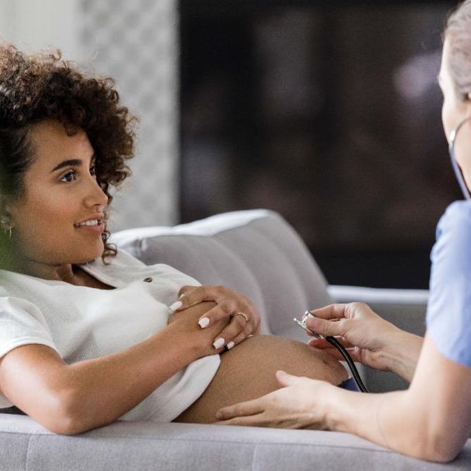 nurse examining pregnant patient