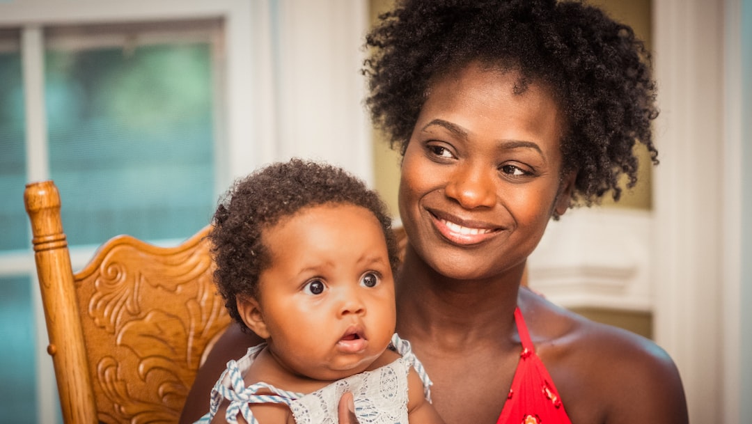 African American woman smiling while holding baby