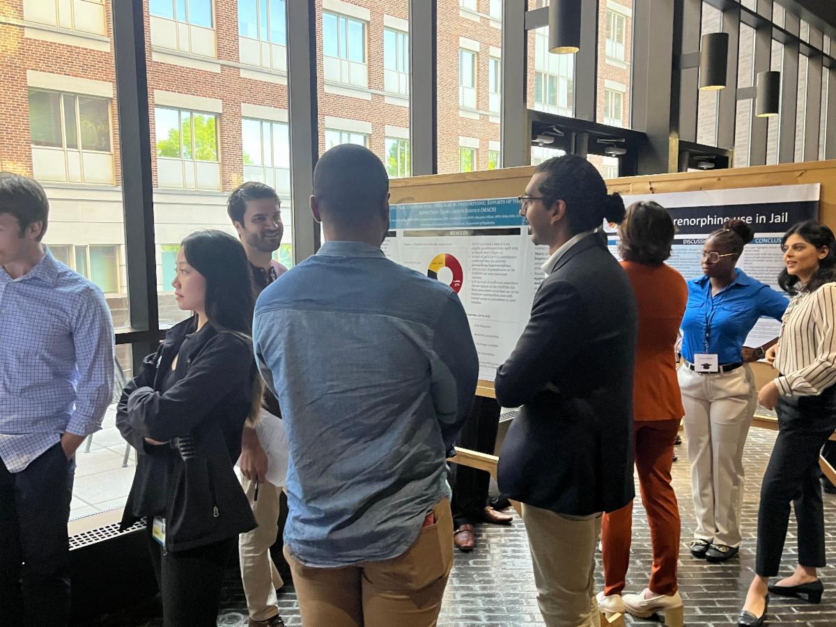 Research day attendees and presenters discuss research posters