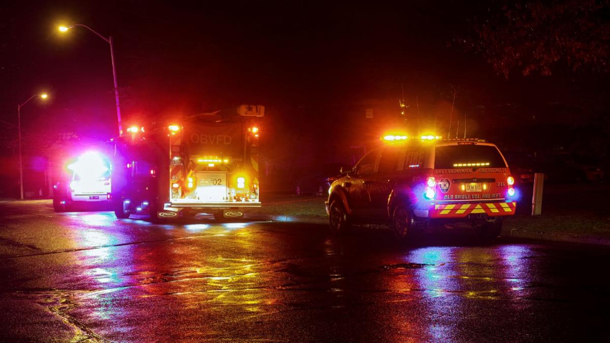 First responder vehicles on road with flashing lights at night