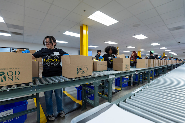 Members of the Cal State LA community at the Los Angeles Regional Food Bank where they help assemble food packages.