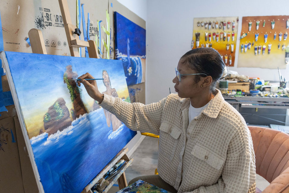 Studio arts major Amanda Flowers painting an artwork.