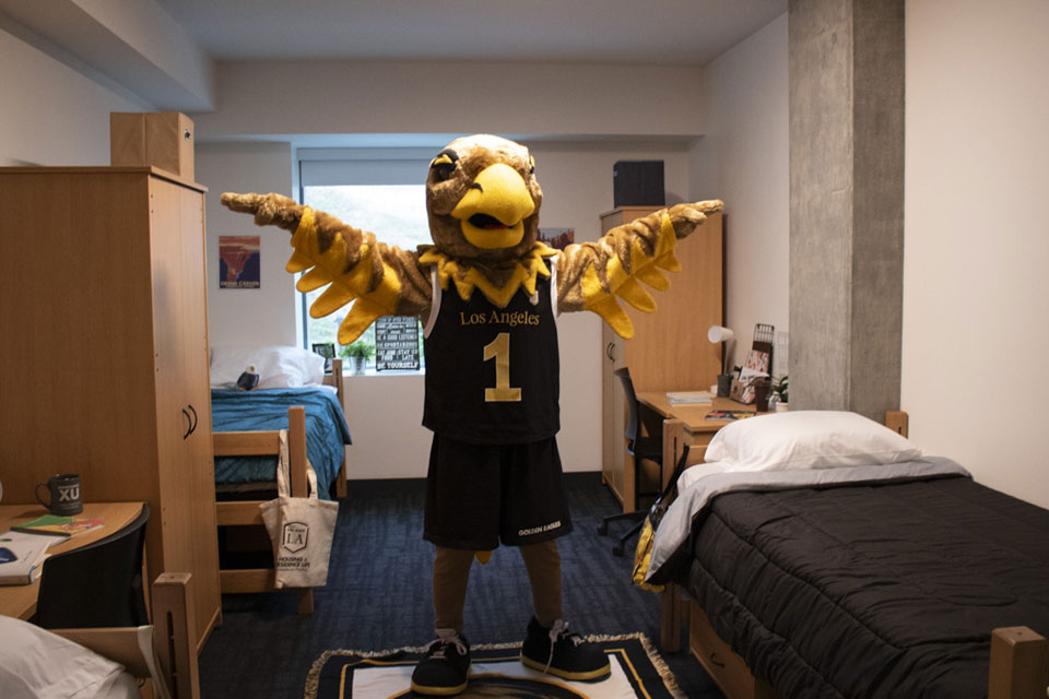 Eddie the Golden Eagle mascot touring campus housing.