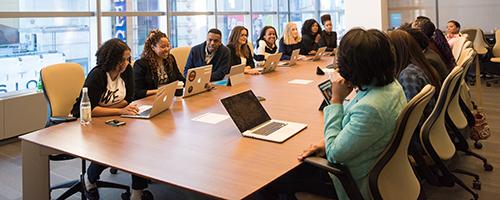 group of people talking around a large table in a meeting room