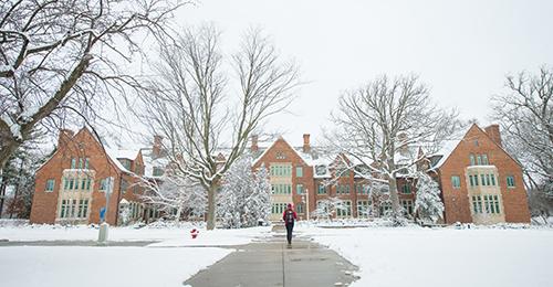 MSU campus covered in snow with student on the sidewalk