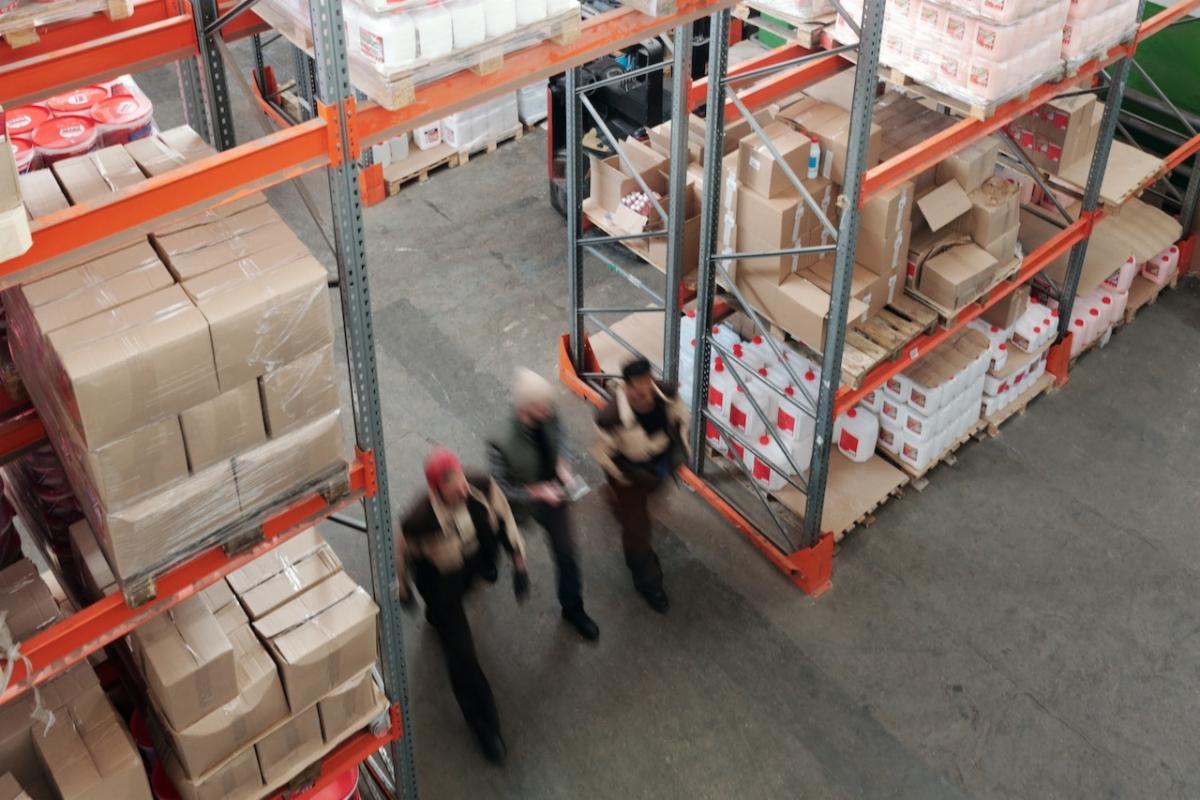 image is taken from above looking down at shelves stacked with boxed and workers walking around