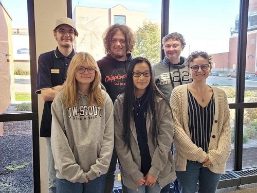 Image of Project SEARCH leader with the students standing in front of a window