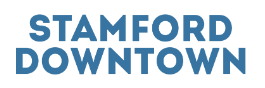 The words STAMFORD DOWNTOWN are displayed in blue letters on a white field.