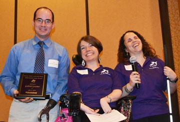 Gabriel Gaumer holding his award next to Carrie and Julia