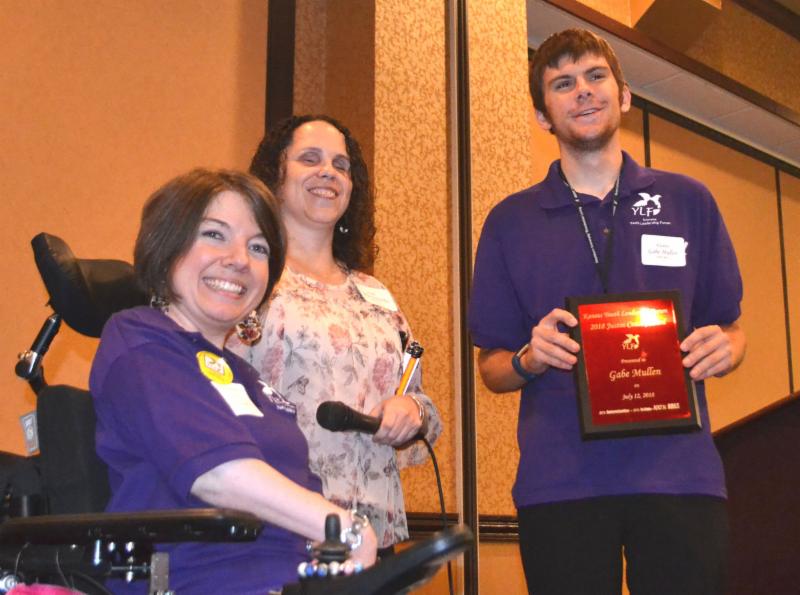 Gabe Mullen takes a photo with Carrie and Julia while holding his award