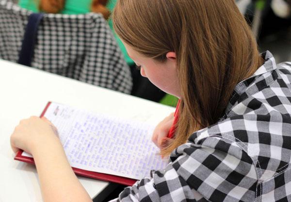 A female high school student writing on a paper