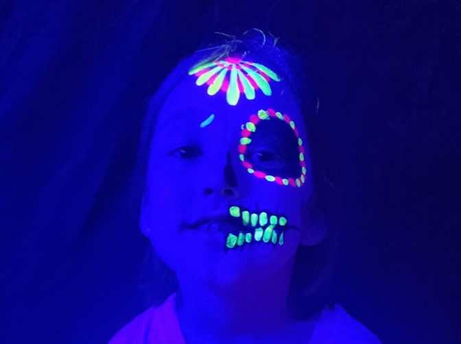 Young girl with UV Face paint glowing