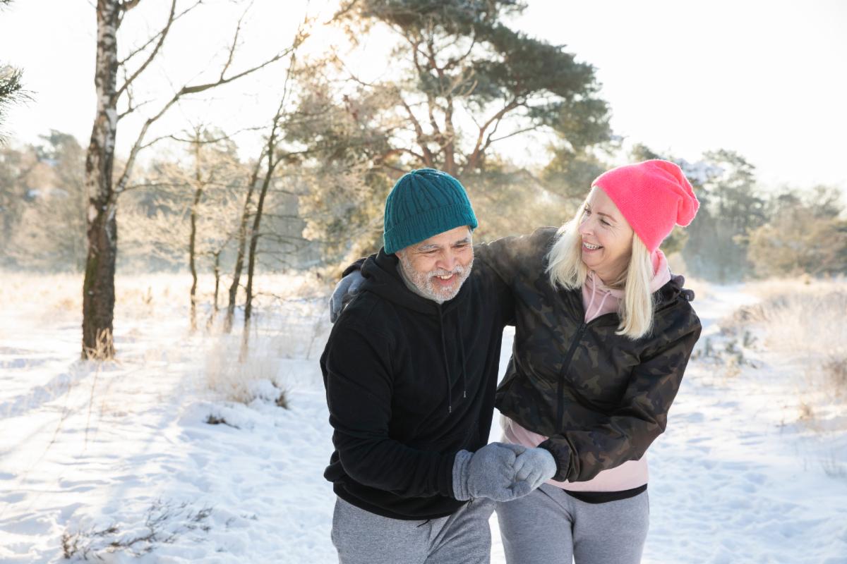 Older couple walking on a snowy trail