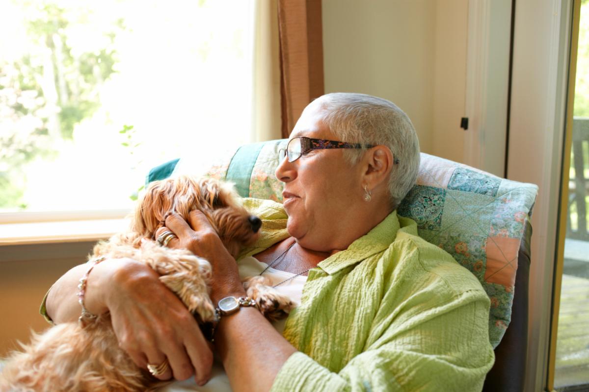 Woman in a recliner cuddling her small dog