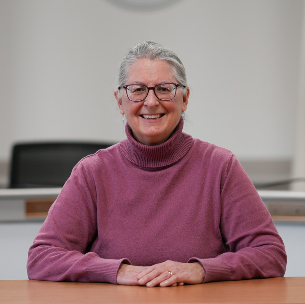 Headshot of Pat Semple wearing a pink turtle neck sweater