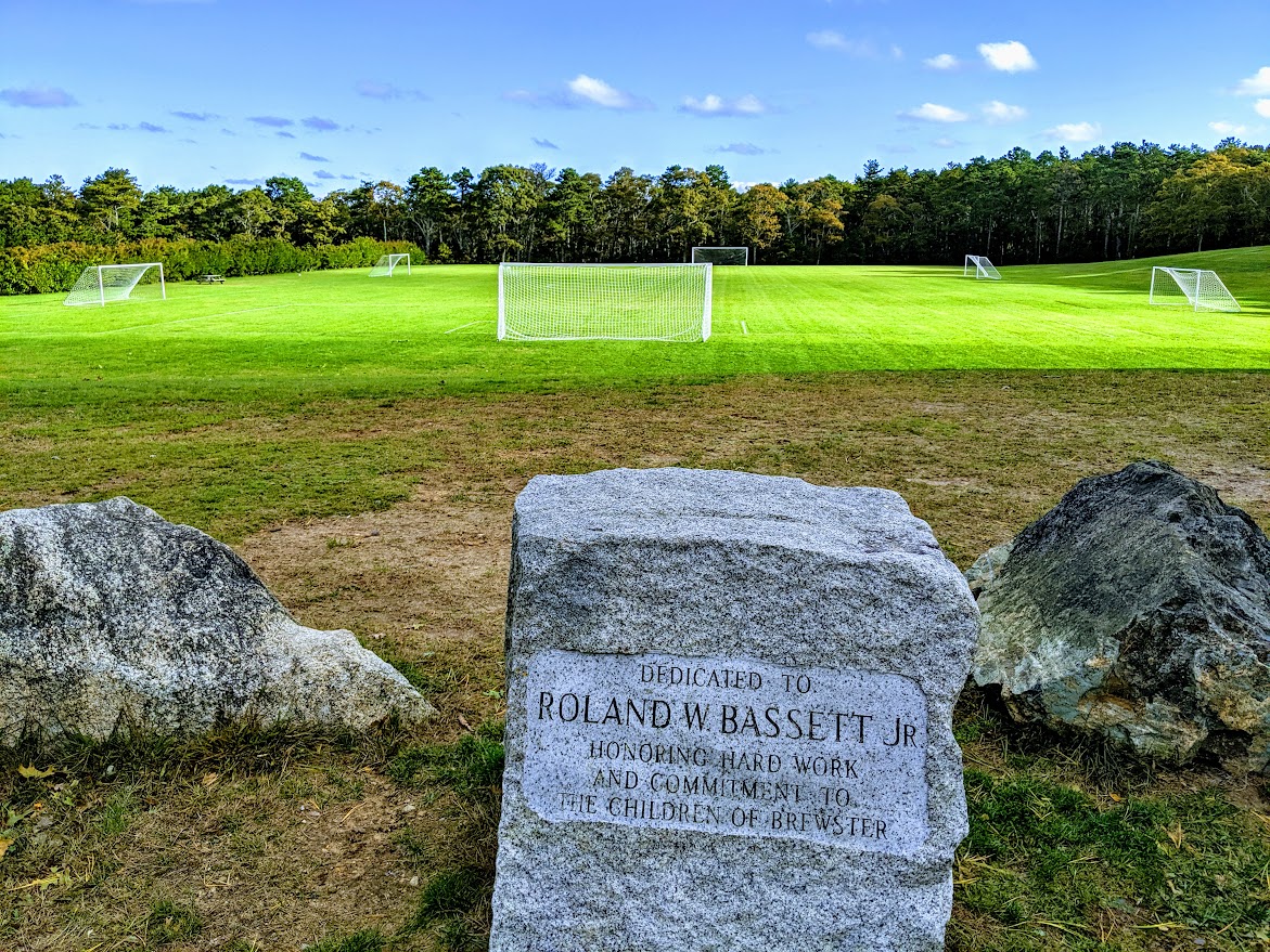 Freemans soccer fields are in the background the memorial rock honoring Roland Bassett is in the foreground