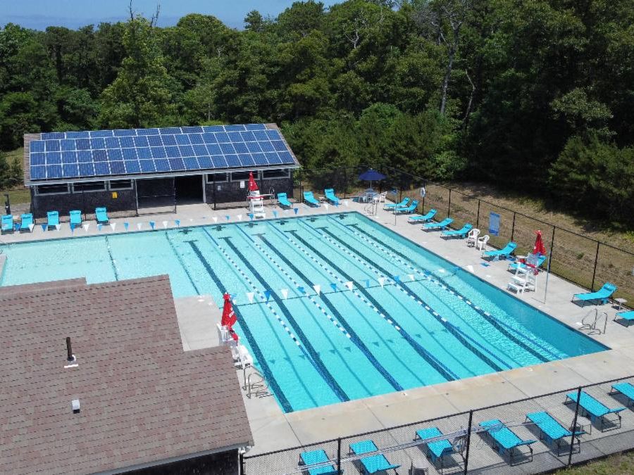 Aerial image of a five lane pool with a pool house and pavilon.