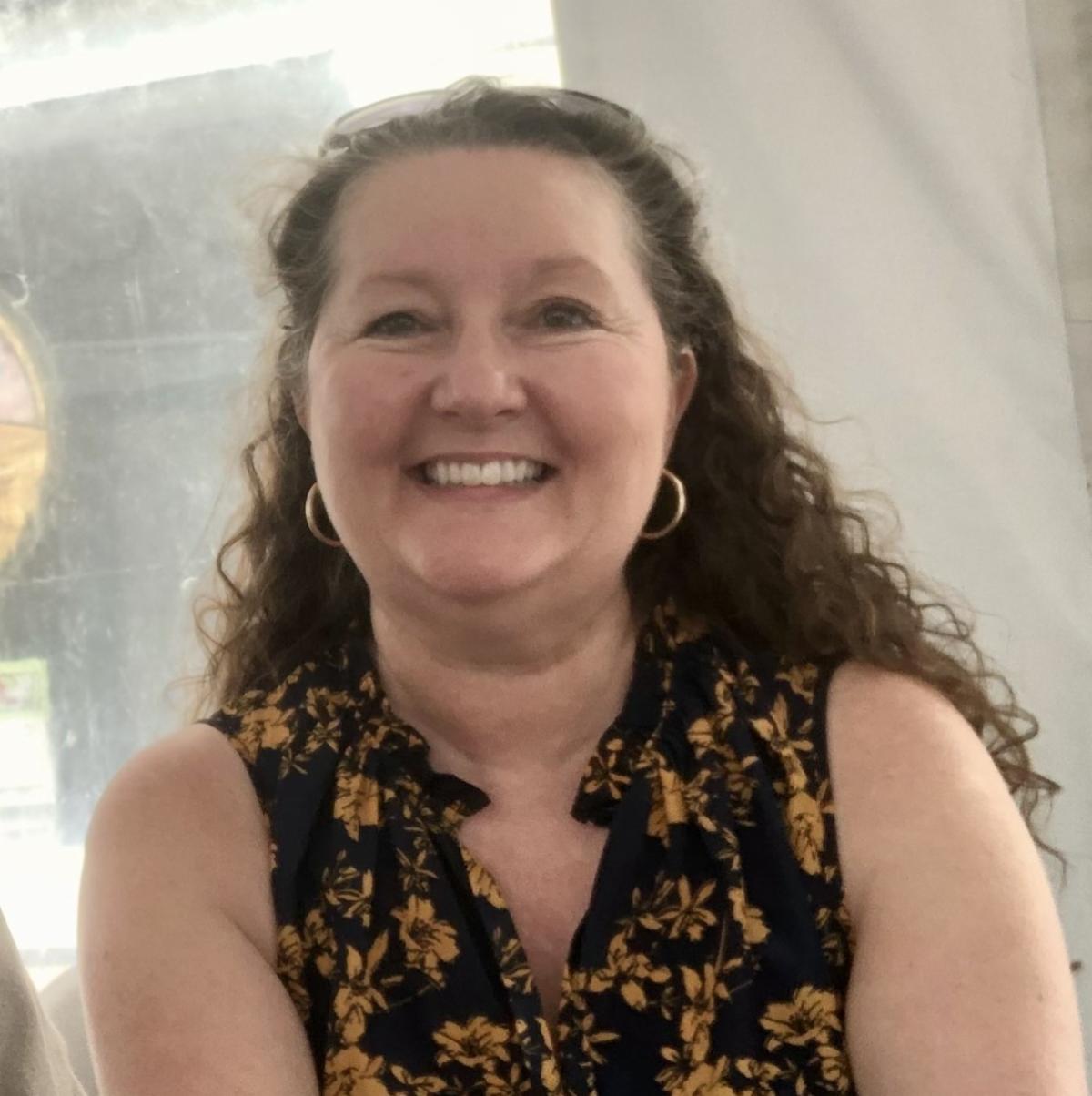 Lisa Vitale is smiling with her curly hair down