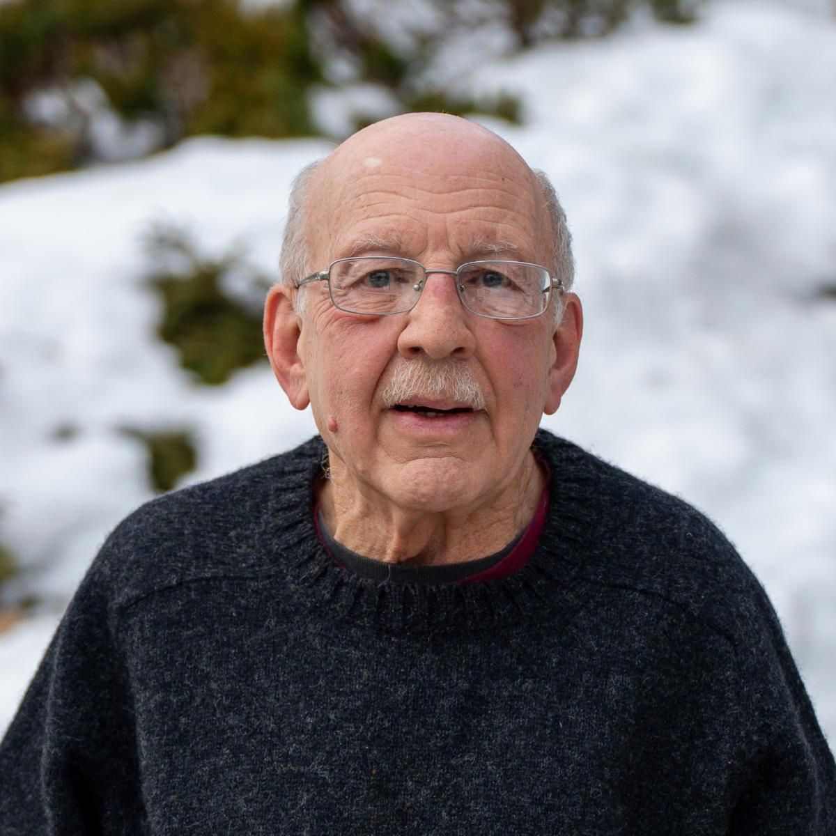 A headshot of Paul Ruchinkas wearing a sweater and glasses