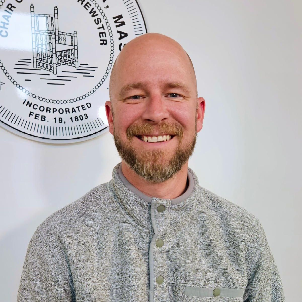 Headshot of Mike Gradone wearing a grey half snap sweater he has a beard and is smiling