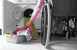 person in wheelchair doing laundry