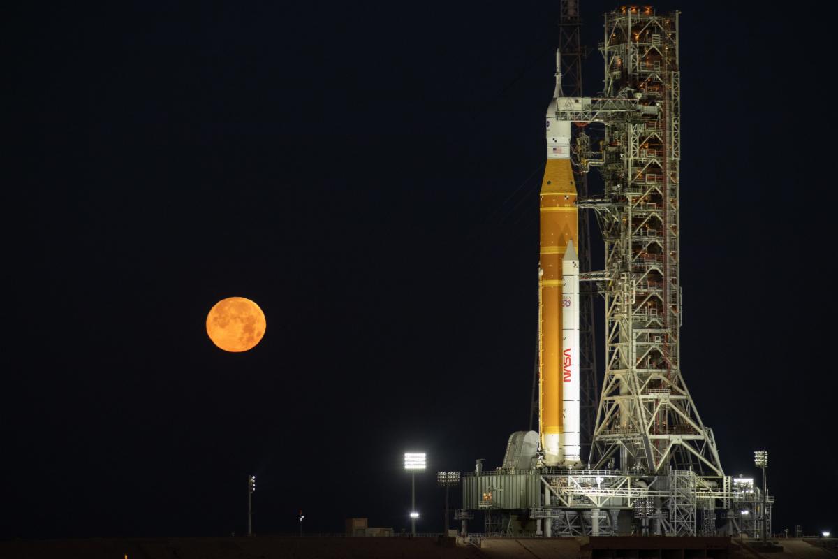 The Moon rises behind NASAâs Artemis II SLS (Space Launch System) rocket and Orion spacecraft atop a mobile launcher at Launch Complex 39B at NASAâs Kennedy Space Center in Florida on Sunday, Feb. 1, 2026.