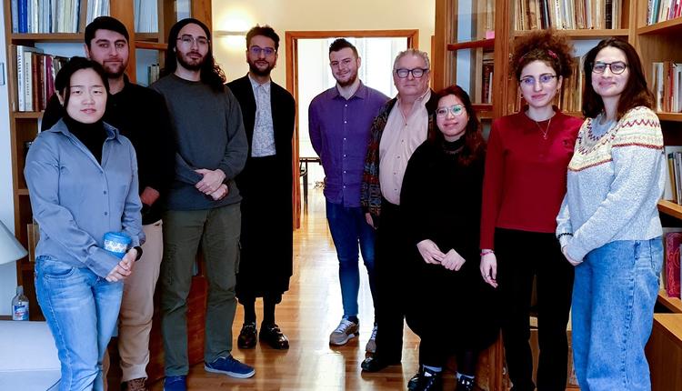 A group of people standing in front of bookshelves.