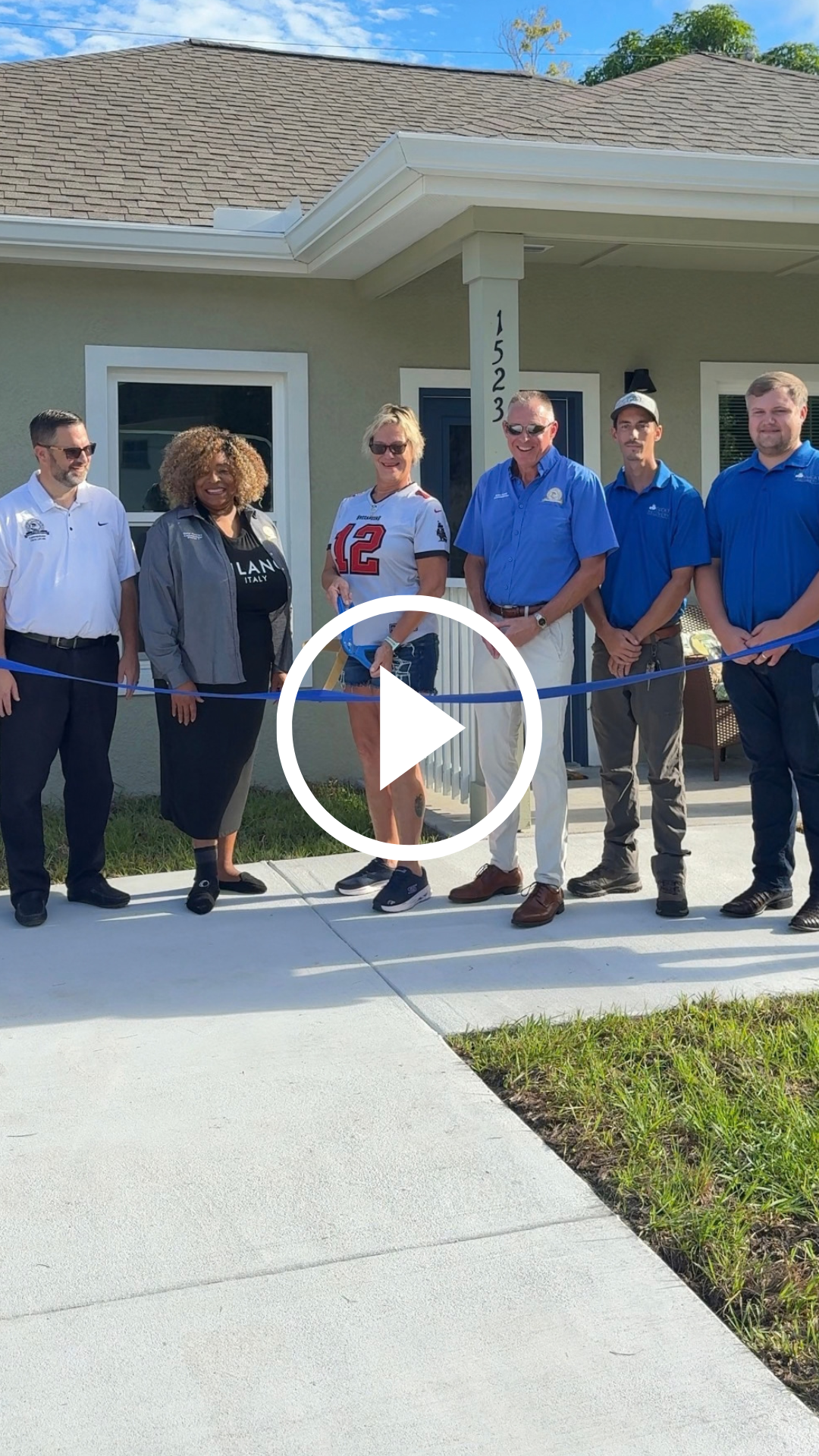 Pinellas County Commissioners cut a ribbon with a new homeowner in front of her newly built home.