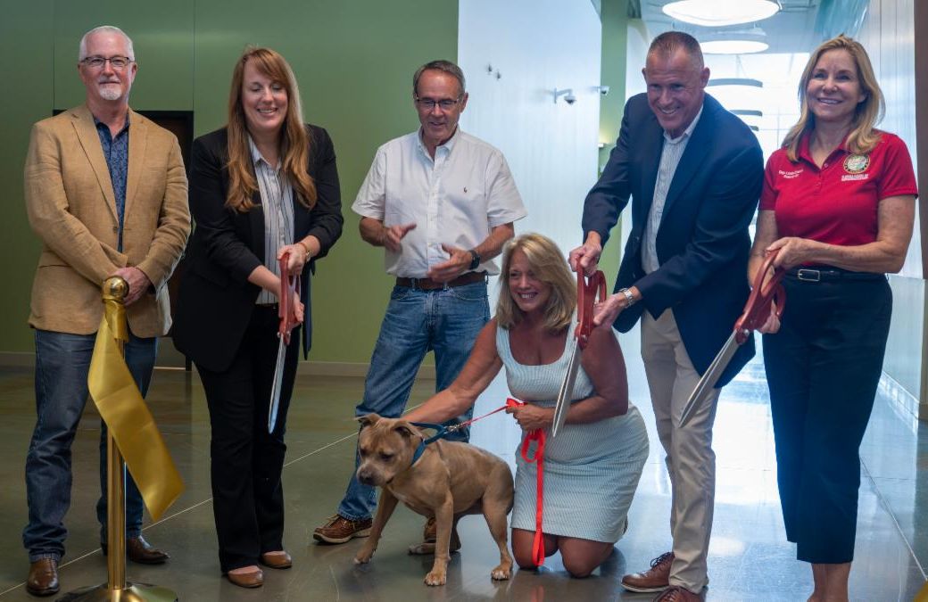 County staff and leadership cut the ribbon on new medical facility with adoptable dog..