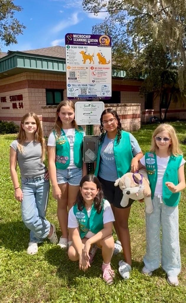 Five girl scouts stand outside in front of Pinellas County Animal Services building.