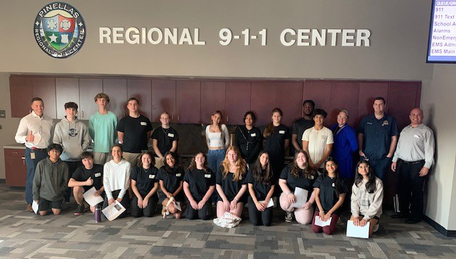 Members of the Youth Advisory Council posed in front of a sign for the Regional 911 Center.
