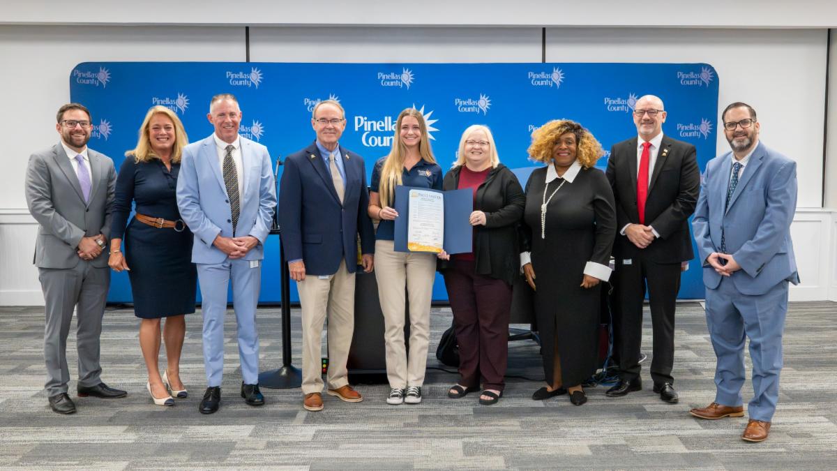 Posed photo of Pinellas County Commissioners presenting 911 leadership with a proclamation.