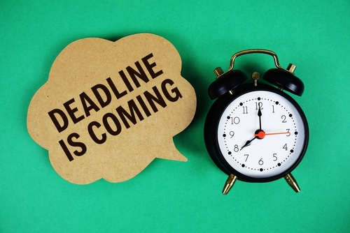 Deadline Is Coming text on speech bubble with alarm clock on green background