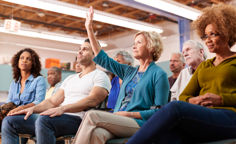 Graphic with character people at a table working with a light bulb above saying to get involved