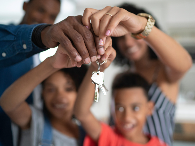 Image of a family of four holding a set of house keys together